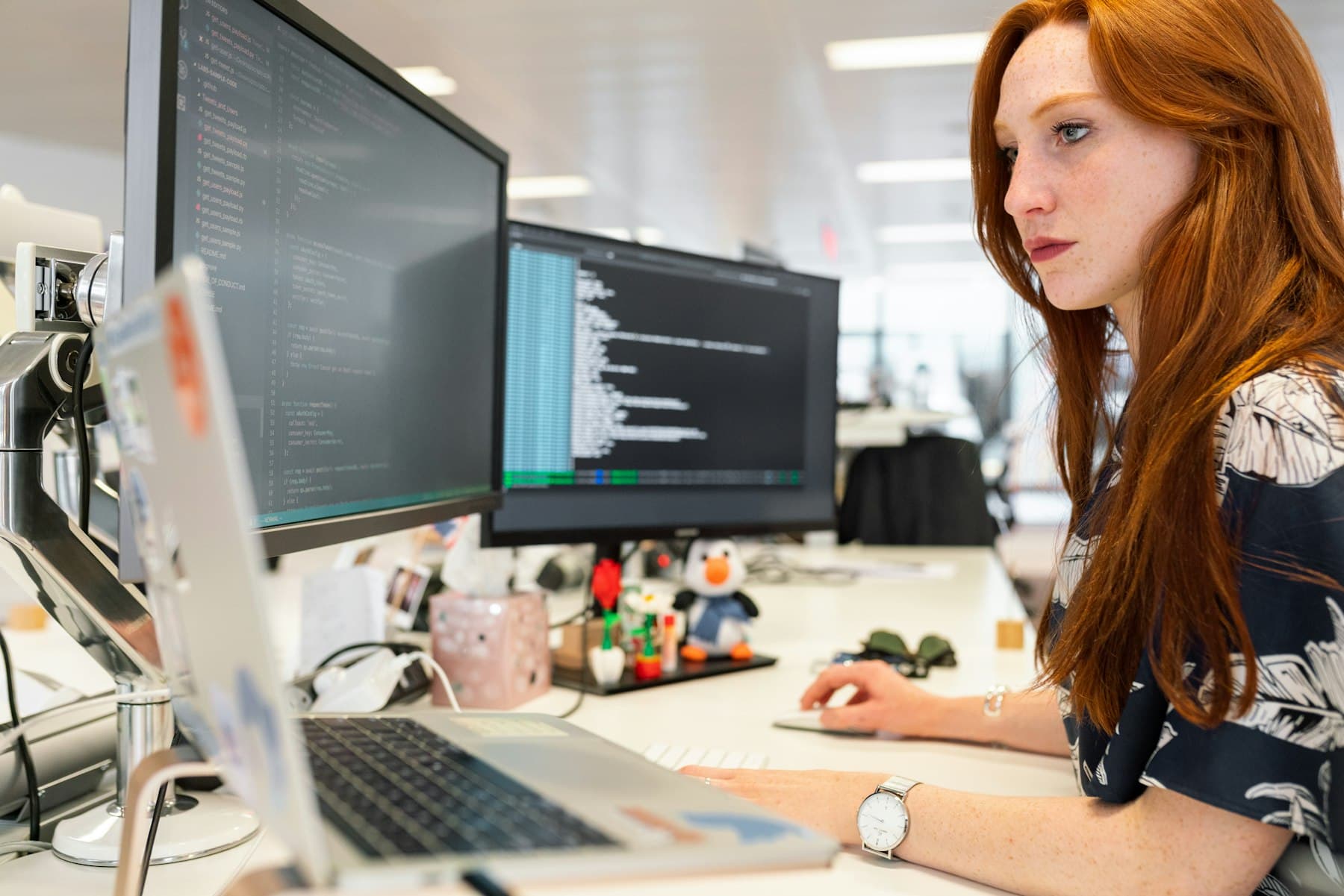 A developer working across two monitors