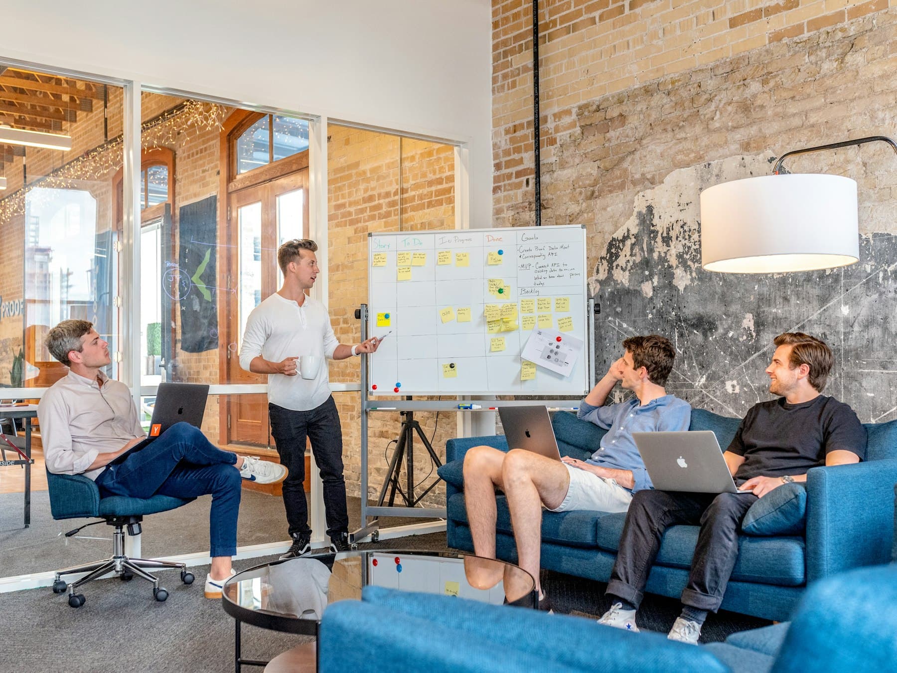 A team in a working session with a whiteboard and laptops